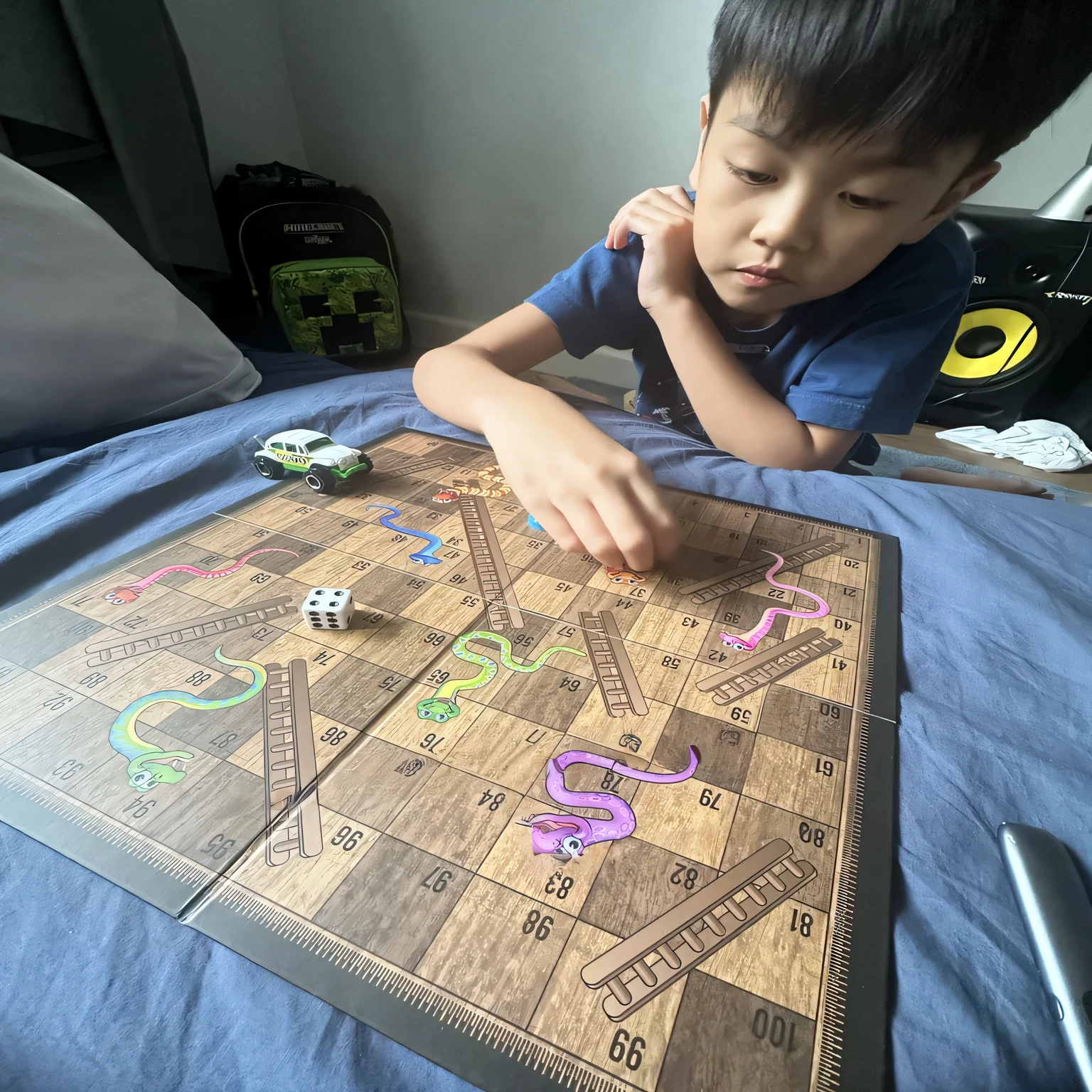 there is a young boy playing a board game on the bed, playing board games, playing games, game board, board game, tabletop game board, shot with iphone 1 0, playing dnd, lawther sit at table playing dnd, board games, board games on a table, game top down view, captured on iphone, games, kids playing