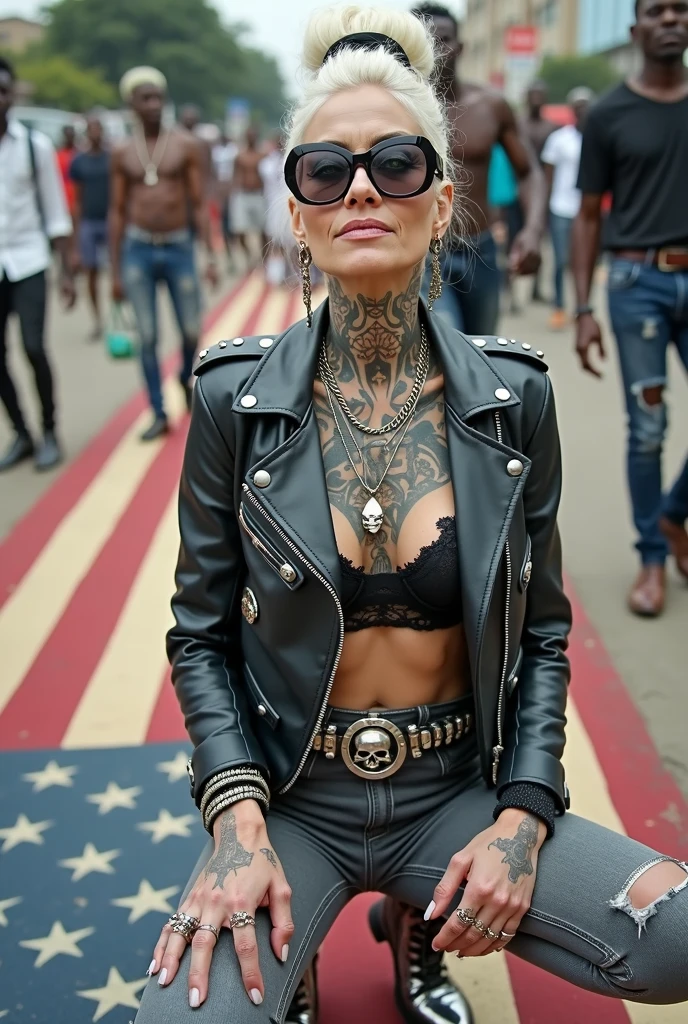 Anglosaxon old milf woman, , blonde platinum hair (beehive bun, black parsley headband), with very light green eyes, extremely pale. Wearing oversized square black maxisunglasses Wearing studded cropped black moto jacket (verical zippers on the sides). Black lace push up bra, dark grey skinny, tight low rise jeans (holes in knees). Silver Chelsea boots with cuban heels. Lots of thick wide studded bracelets, chain collars and big rings. Tacky wide studded leather belt, with big skull and bones round buckle. Long earrings with chains. Squatting on a large ragged, dirty usa flag, looking at the photographer. Craving heavily. Hands on knees. Waste and trash all over the floor. Her studded leather bag, thron away. Looking at the camera, chin up. Toned abdominals, thin neck, slim legs and thin arms. Neck, chest, belly, hands and arms completely tattoed. Street of Nairobi, crowded with shirtless men in jeans