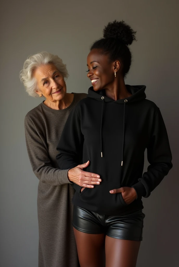 black woman hair in a bun black hoodie black leather short shorts being fucked in the ass by a old grandma in a dress standing behind her with her hand on her ass