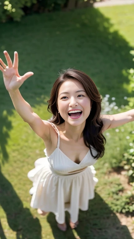 A drone-captured aerial view of a beautiful Japanese woman standing in an open field, looking up towards the sky with her arms fully raised in a joyful, celebratory gesture. The perspective is from directly above, highlighting the height and distance as the drone captures her entire body in the frame. She has a delicate and symmetrical face with soft, refined features that remain visible despite the top-down angle. Her dark, glossy hair flows around her as it is gently tousled by the breeze. She is wearing a flowing white dress that contrasts elegantly with the lush green grass beneath her, and her long, graceful legs are visible in the full-body shot. Her expression is serene and joyful, her large, expressive eyes gazing upwards as the sunlight casts soft shadows, enhancing the depth and realism of the scene. The aerial view emphasizes the sense of openness and freedom in the moment.