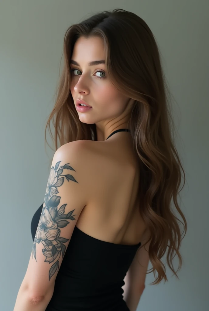 A woman with a medium complexion, likely in her late teens to mid-twenties, stands with her back to the camera. Her long, light brown hair cascades down her back, styled straight and loose with a center parting. Her black, strapless top reveals her back and shoulders, and appears to be made of a stretchy material like spandex or a spandex blend, fitting her body closely.

On her right upper arm, a black ink tattoo of a flower with a detailed design covers a significant portion of her skin. The tattoo is intricately designed and exquisite, with delicate petals and intricate details that catch the light, tiny colored like a gradient fall of colors;

The subject's posture is straight, with her arms relaxed at her sides. Her head is turned to look over her right shoulder, her eyes looking directly at the camera with a hint of intensity. Her expression is otherwise neutral, with a subtle, soft quality to her features, imposing a mystery and quite sensuality 

The background is a light grey color with a soft gradient, giving the image a sense of depth and dimensionality. The lighting is soft and diffused, coming from a source in front of the subject, and illuminates her face and upper body evenly. There are no harsh shadows or distractions, keeping the focus squarely on the subject.

The image is high-resolution, with good detail and clarity. The subject's features, tattoos, and clothing are all clearly visible, with a level of texture and dimension that draws the viewer in.

Image Specifications:

Resolution: High-resolution
File format: JPEG or similar
Dimensions: 3000 x 2000 pixels or similar
Color depth: 24-bit or similar
File size: 5-10 MB or similar