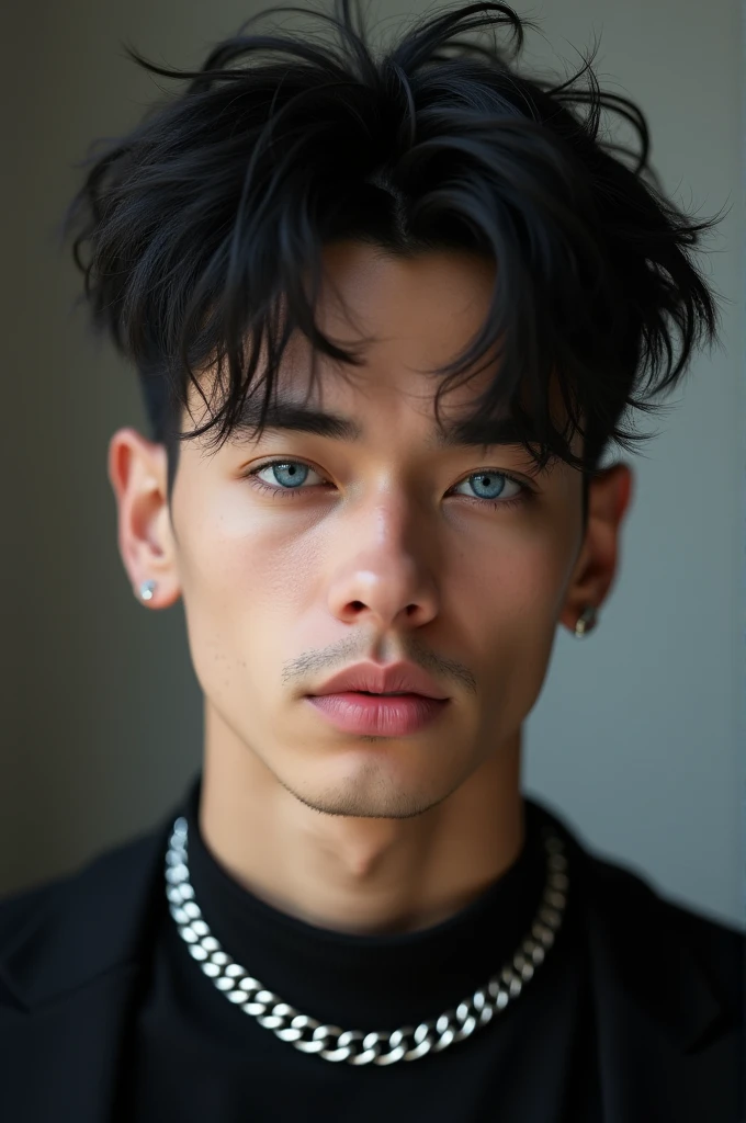 A man with black tik toker hair with dark blue eyes wearing a black top with a silver chain