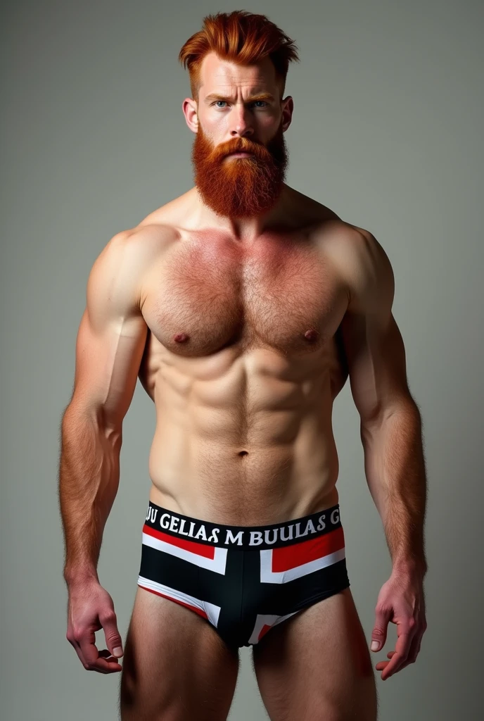 A strong, bearded red-haired man wearing underwear printed with the black and white flag of the State of Prussia, written in capital letters “GUARIJO” in large letters on the elastic of the underwear.