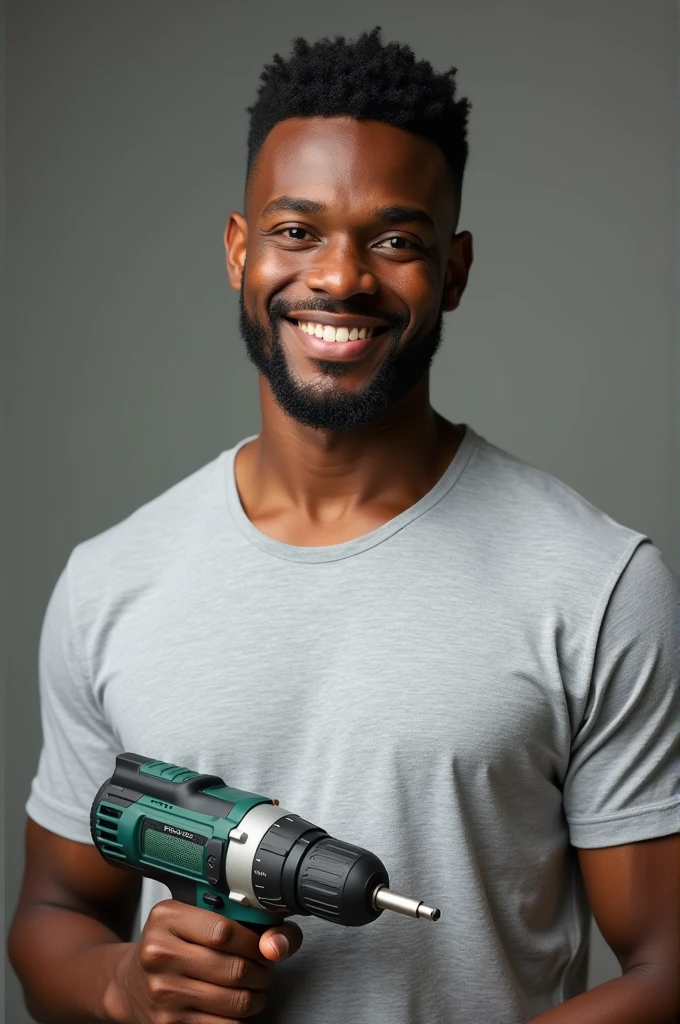Smiling black man with goatee, neat black hair, light gray t-shirt, holding a drill in his hand