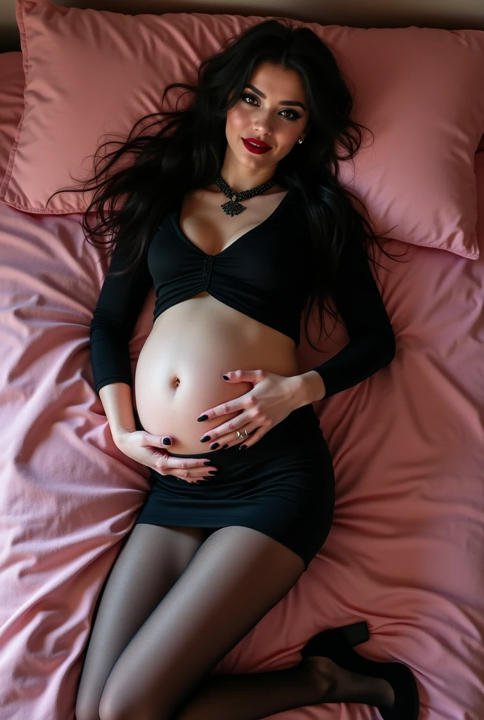 Happy pregnant gothic girl wearing black crop top and mini skirt and tights and high heels while lying on a pink bed 