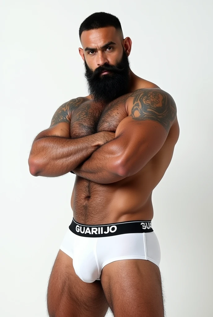 Strong, bearded mixed-race man posing in white underwear with the words “GUARIJO” written in large capital letters on the elastic of his underwear.