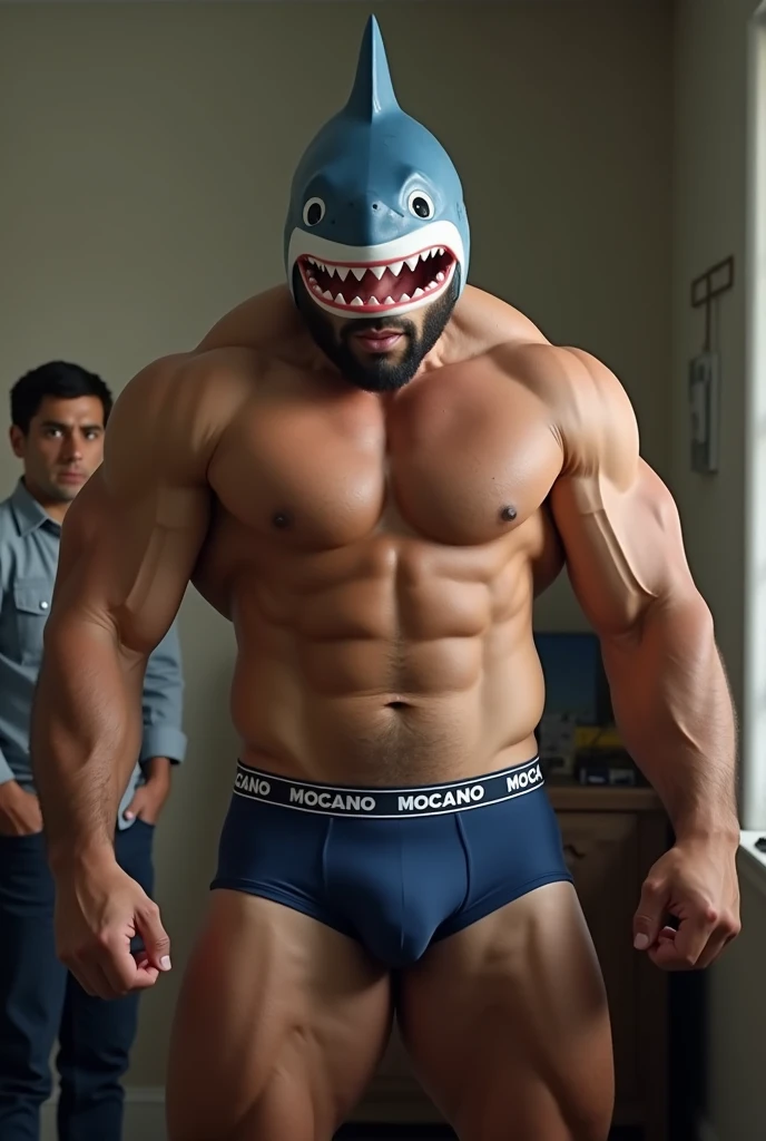 Strong and muscular mixed race man, with a shark head costume on his head, with navy blue underwear with “MOCANO” written in large capital letters on the elastic of the underwear, with a curious man watching in the room.