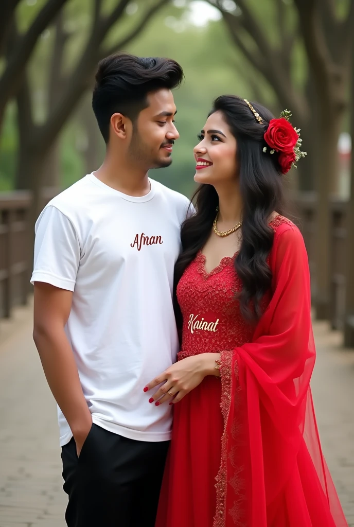 Create a realistic picture of a 2 beautiful young couple standing close to camra the boy wearing white tshirt and black pant looking toward the gril with smiling face and the girl wearing Red bride dress looking to the face of boy while smiling . the name 'afnan ' should be written on biy shirt and name 'Kainat' should be written on girl dress at chest.