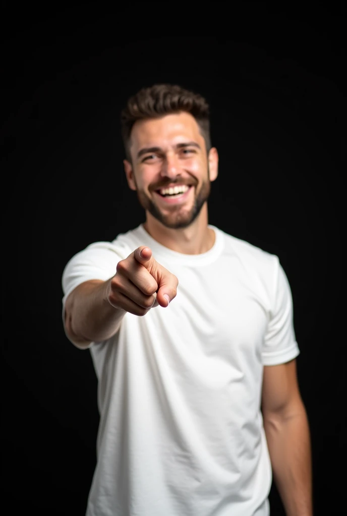 A man with a big smile on his face. He is wearing a white t-shirt and is pointing his finger towards the camera. The background is black.
