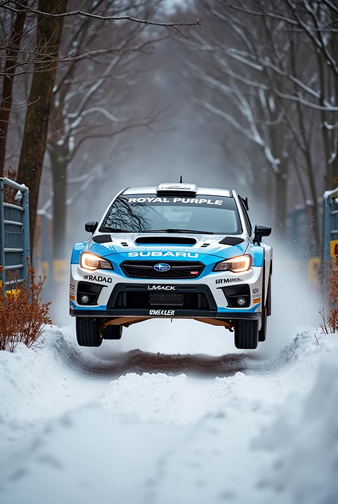 A dynamic action shot captures a Subaru rally car in mid-air while performing a jump on a snowy, forested track. The vehicle, predominantly white with sky blue accents, features multiple sponsor logos including 'Royal Purple', 'PIAA', 'Hermont SportsCar', 'DMACK', and 'ECKLER'. The Subaru logo is prominently displayed above the front grille, and 'RALLY RACING' is written across the windshield in white. Bright headlights illuminate the snowy scene, creating a high-contrast effect against the falling snow. The car's front bumper displays 'Royal Purple' and 'ECKLER' logos, with 'PIAA' visible on the side. The background consists of leafless trees covered in snow, with branches laden with rust-brown foliage adding texture to the wintry setting. A metal fence with horizontal bars stretches across the left side of the image, partially wrapped with yellow caution tape. The snow-covered ground below the car is visibly disturbed by its tires, with a dusting of snow visible on the surface. The scene is filled with a flurry of falling snowflakes, emphasizing the harsh winter conditions. The lighting is natural daylight, slightly diffused by the overcast sky, which enhances the stark contrast between the white snow and the car's colors. The overall composition creates a sense of speed and intensity, capturing the thrill of rally racing in a wintry forest environment.