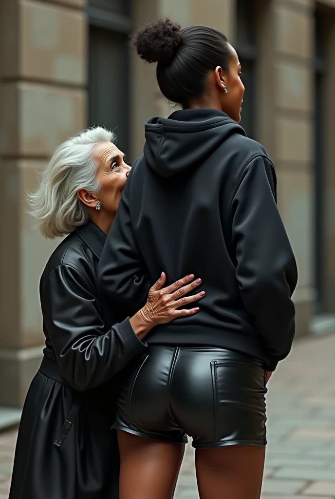 black woman hair in a bun black hoodie black leather short shorts rea;;y in shock as a old grandma in a dress on her knees kissing her ass behind her hand is in her ass holding her ass
