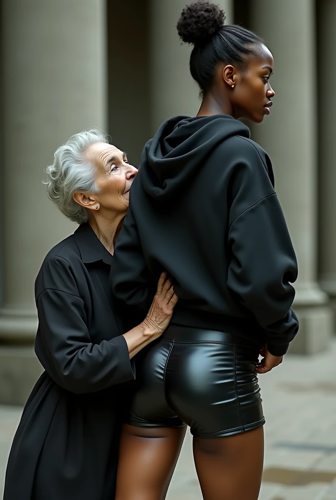 black woman hair in a bun black hoodie black leather short shorts rea;;y in shock as a old grandma in a dress on her knees kissing her behind her hand is in her asslding her ass