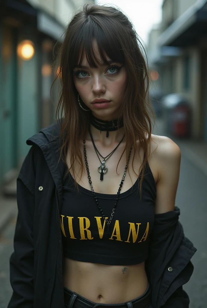 A grunge girl with light brown hair and light blue eyes in a nirvana crop top and bangs.
She must have some eyeliner on the side of her eyes