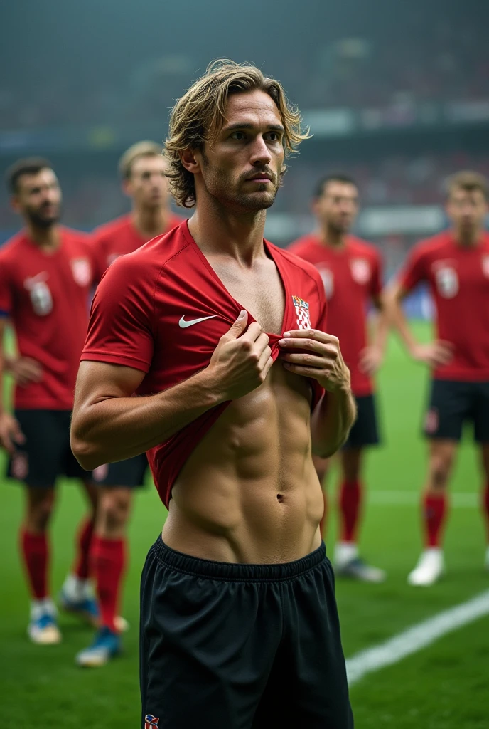 Luka Modric taking of his clothes on the soccerfield. Other soccer Players are looking at him