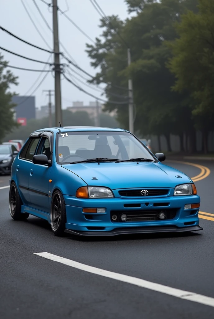 A 1999 toyota starlet Glanza in the color of blue  matte with a low bumper 