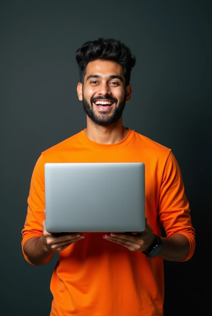 The image shows a young Indian white man with hair,smiling and holding up a laptop.He is wearing a orange shirt and appears to be happy and excited. The background is black
