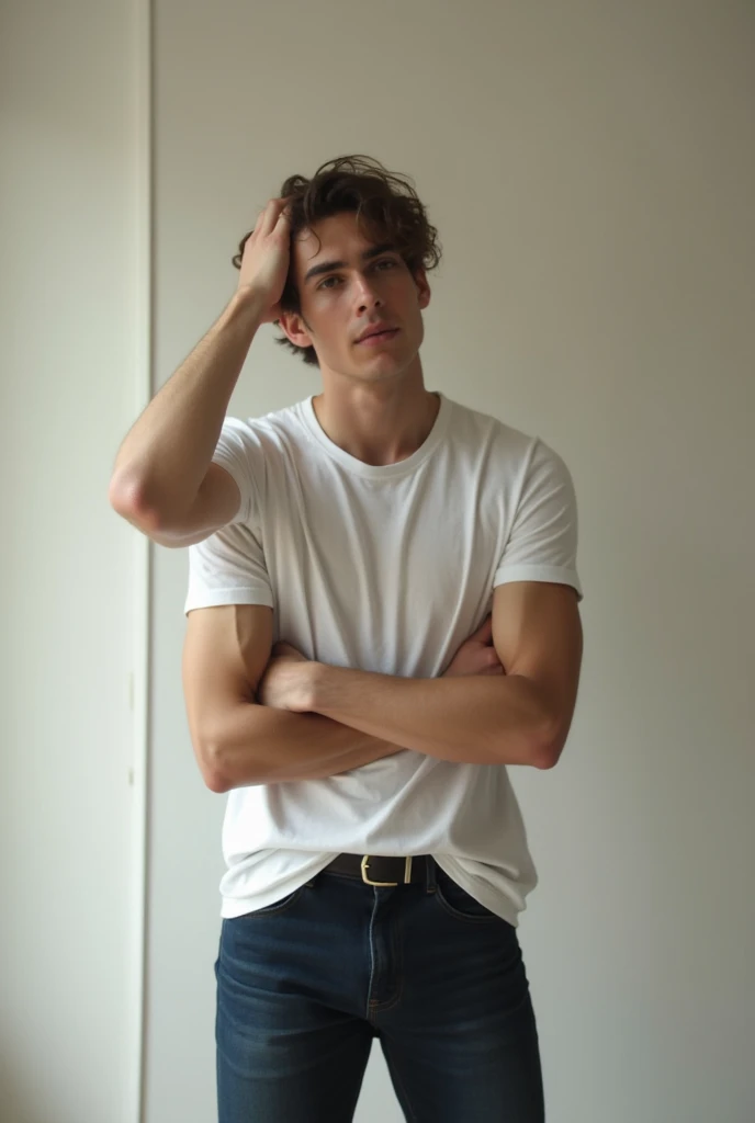 Photo of a handsome young male standing facing forward in a pale room and has his right hand placed straight on top of his head as if he is moving