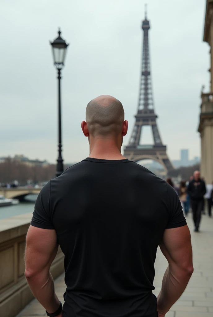 create a realistic photo of a bald man in Paris. showing the Eiffel Tower, he is completely turned away, you can't see his face, of costs for a camera, wearing a chic basic black t-shirt. he is tough, non-protuberant musculature, and white in color