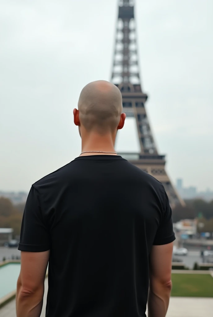 create a realistic photo of a bald man in Paris. showing the Eiffel Tower, he is completely turned away, you can&#39;t see his face,  of costs for a camera, wearing a chic basic black t-shirt.  white in color and the tower far from the photo