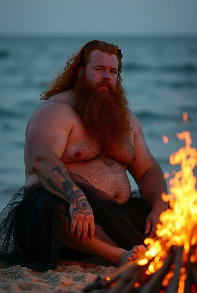 strong fat red-haired bearded man sitting on the sand looking at the sea. he wears gables a black tulle skirt photo with the bonfire lighting appearing. illuminating the body he