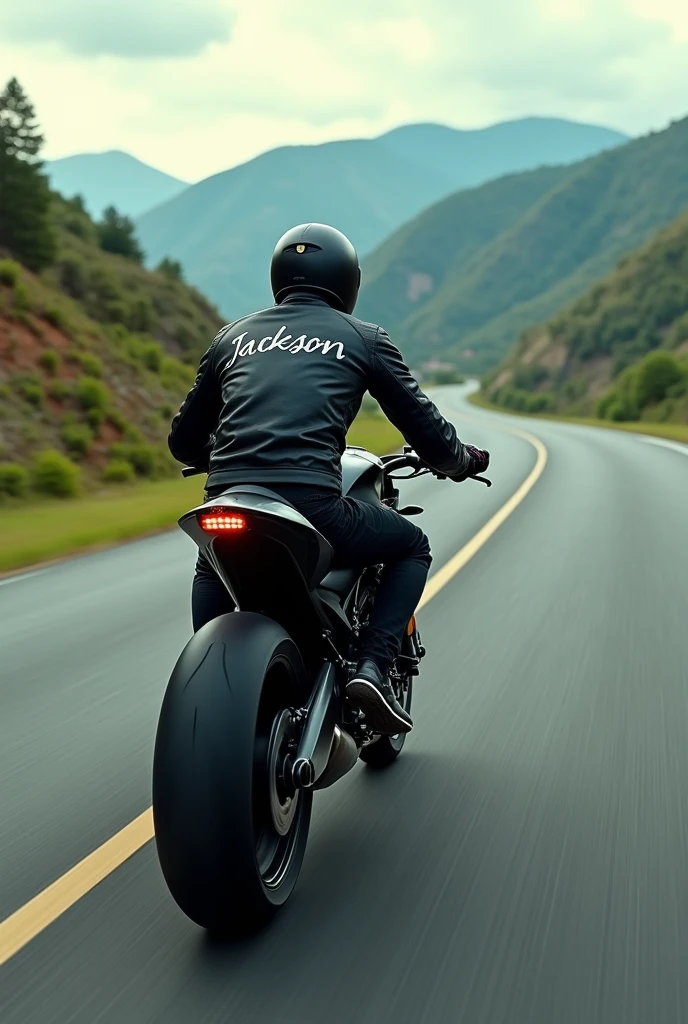 A man in black clothing and a black helmet riding a motorcycle with the name Jackson in large letters on the back on a luxury highway