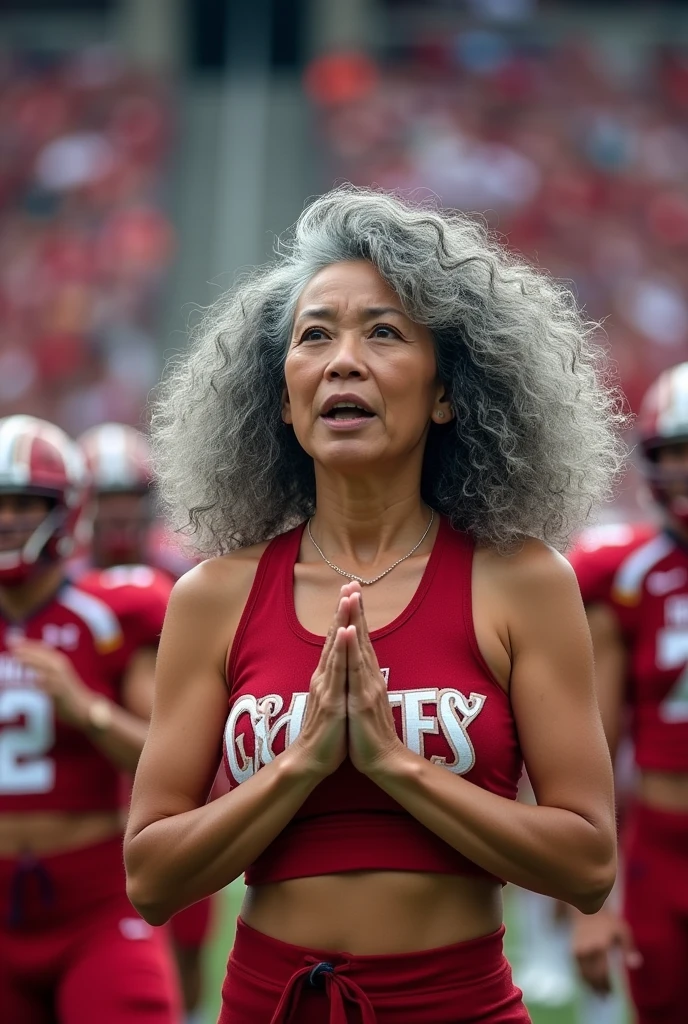 In the image, we encounter an enchanting scene featuring a charismatic gray haired female cheerleader, a vivacious 50-year-old of Chinese-American heritage. Her long, beautifully completely gray curly hair cascades gracefully, gracefully illustrating her confident spirit. As she passionately encourages her team, her energy radiates, infusing the atmosphere with an electric buzz. Alongside her, male football players intensify the background with their determined presence. This vibrant photograph captures the captivating essence of a spirited cheerleader, exuding both wisdom and allure in equal measure. The impeccable image quality allows every meticulous detail to shine, bringing this remarkable moment to life in vivid color and sharp clarity.