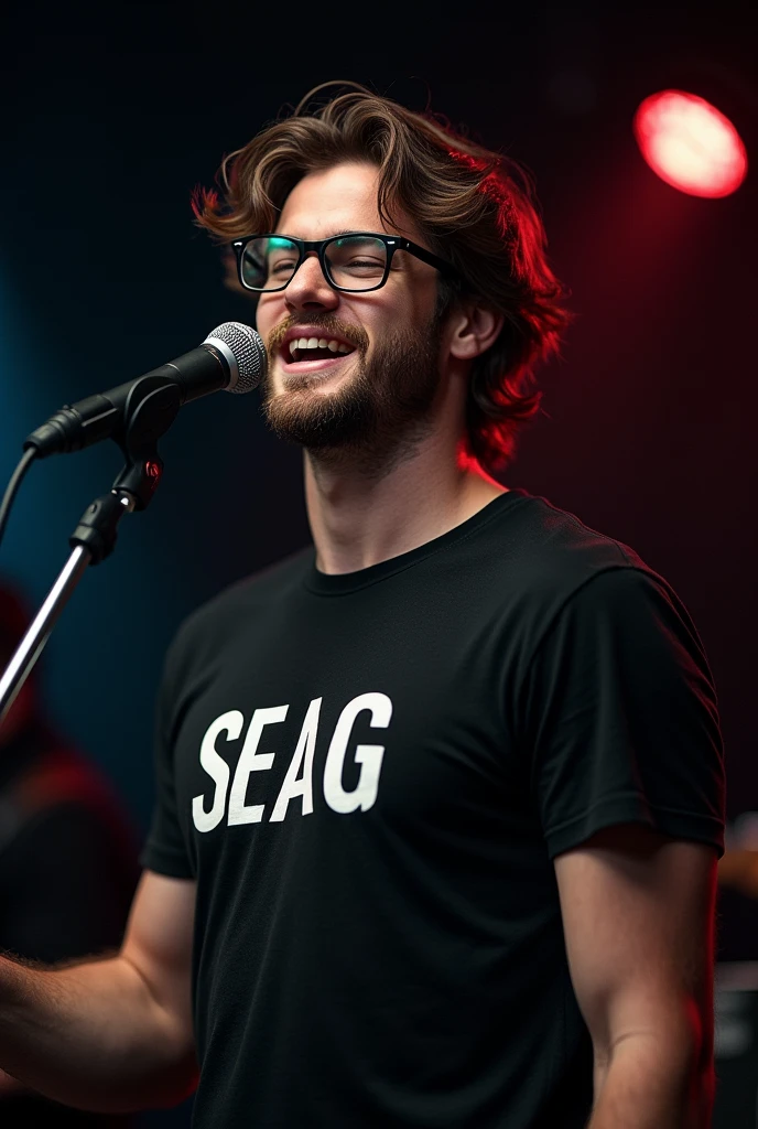 A handsome boy with slight long hair and beard wearing a glasses singing Infront of mic wearing black t-shirt written "SEAG" on it