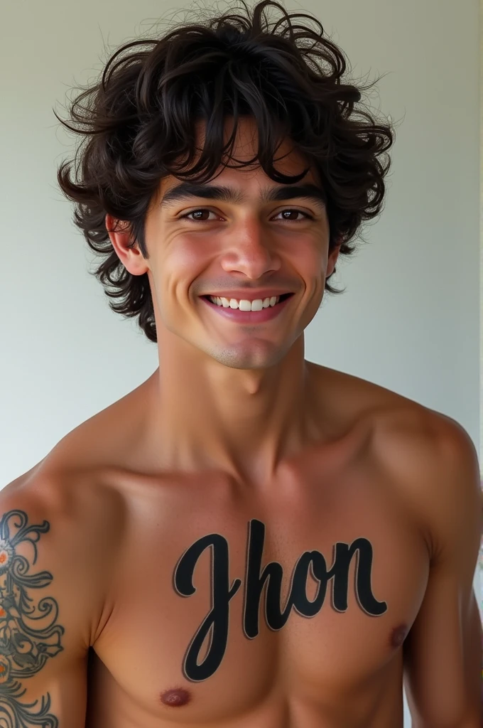 A young dark-haired man with curly hair, shirtless with a tattoo of the name jhon smiling