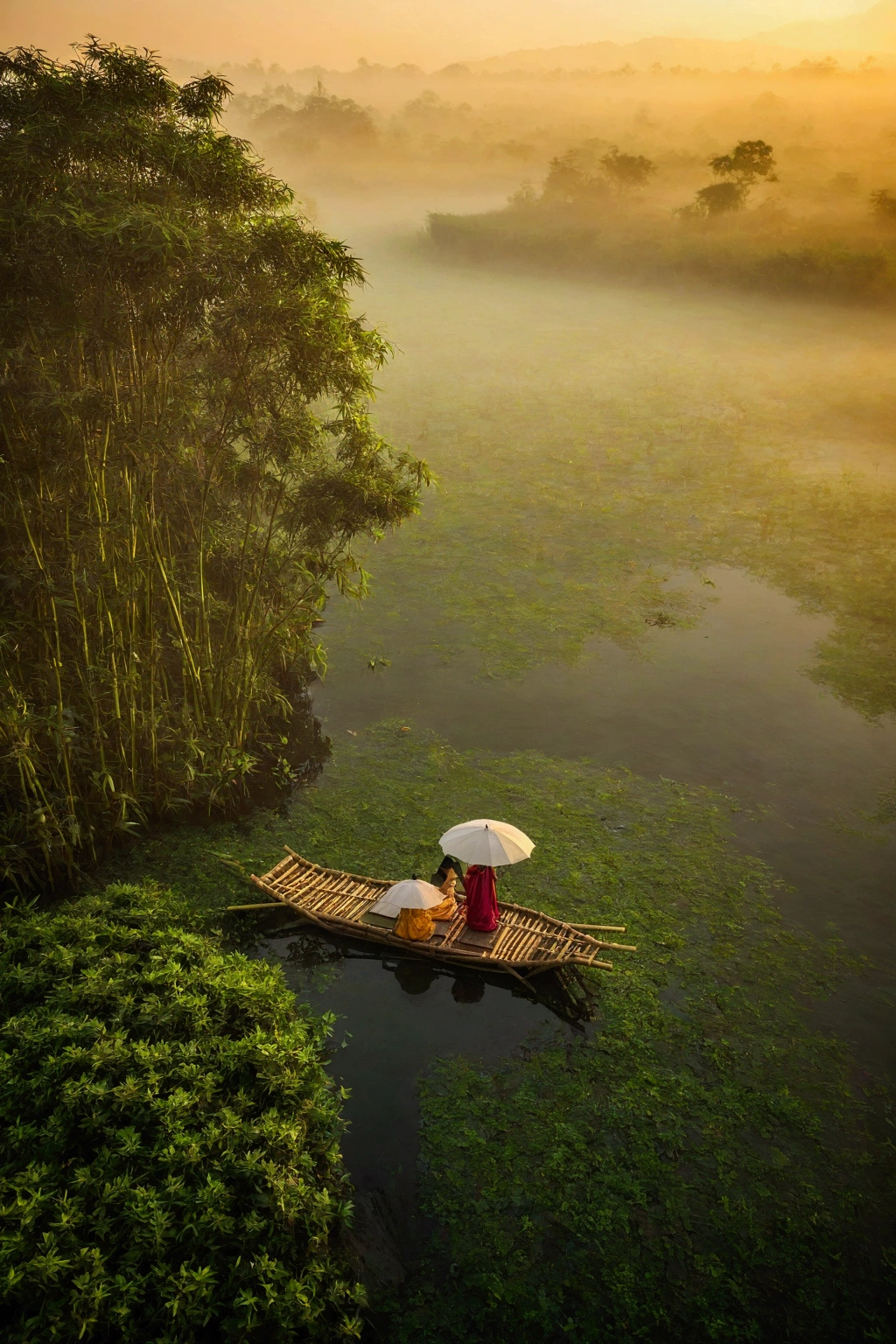 Misty,Sunset through the fog,Aerial view of a 92-degree angle shot of a bamboo raft tied with bamboo,A woman holding an umbrella in front of a bamboo raft,There is a boatman behind,Like a Chinese landscape painting, it also looks like a fairyland, as if there is Buddha's light.,Maximum resolution,All the details can be seen clearly,Cinematic color grading