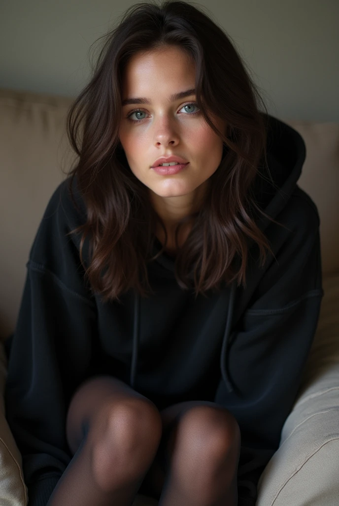 dark brown hair、full body portrait、teaing smile、 she wears a black hoodie.、black pantyhose、adult german woman、blue eyes、showing her black pantyhose、lying on a couch、young german woman、wide angle、 she has ocean blue eyes.、