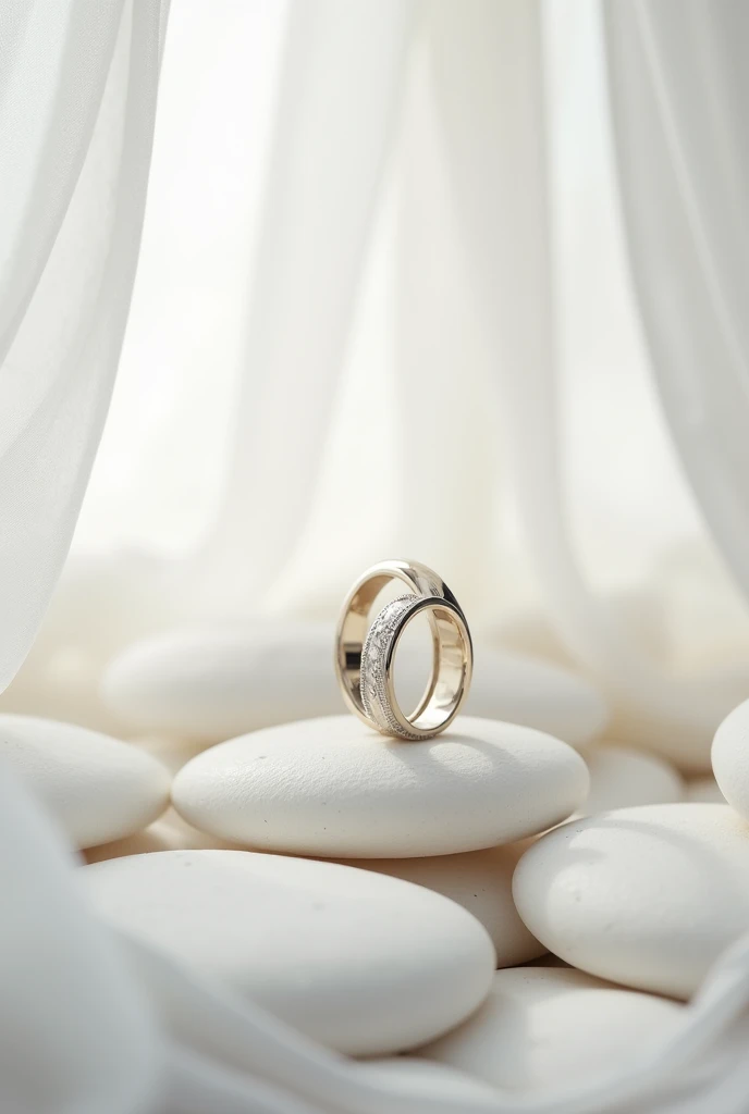 Photo of white gold wedding rings close up, standing vertically next to each other on large white stones surrounded by the bride&#39;s delicate veil in the foreground and background