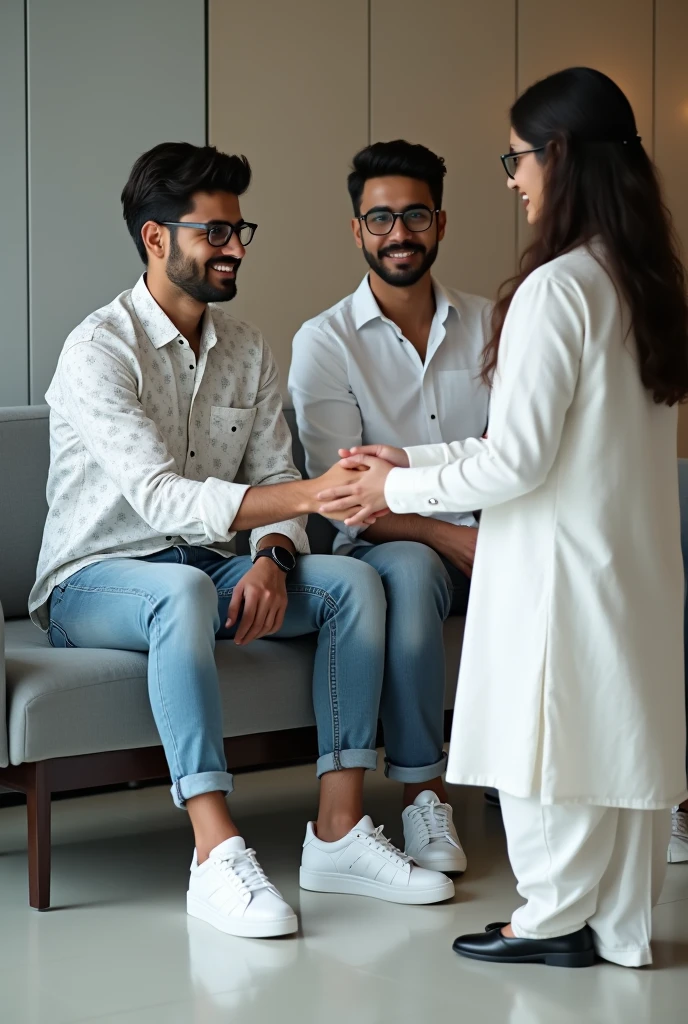 Two young men are waiting for their girlfriends in the reception area of ​​the office. One of the young men is wearing a white printed shirt, jeans, white shoes and smart watch and the other is wearing a white full sleeve t-shirt, jeans, glasses and black sneakers. His girlfriend comes there wearing a white Indian suit, black pallu, white shoes and glasses. Then she shakes hands with both the boys.