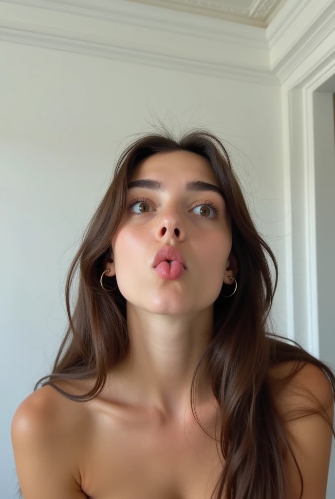 Amateur photography of a young woman with long, dark brown hair that falls loosely over her shoulders. She has a light skin tone and a youthful appearance, with a slightly flushed complexion. Her eyes are wide open, looking upward and to the left, with a playful, mischievous expression. She has her tongue out, sticking it playfully to the side. Her eyebrows are well-groomed, and she wears small, silver hoop earrings. The woman appears to be topless, though her shoulders and upper chest are visible, indicating a nude state. Her breasts are not visible in the frame.,
The background is minimalistic, consisting of a plain white wall with a subtle texture and a white ceiling with crown molding, indicating an indoor setting, possibly a bedroom or bathroom. The lighting is soft and even, casting gentle shadows and highlighting her features. The overall mood of the photograph is light-hearted and playful, capturing a candid moment of youthful exuberance.,