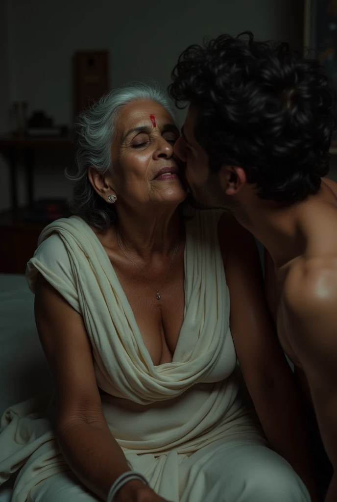 photo of Beautiful Indian Mature Old Aunty, Dark Skin, wearing White stole around her neck, Nude, Breasts Exposed and sitting on Bed, Kissing a Boy, Dim light in the room.