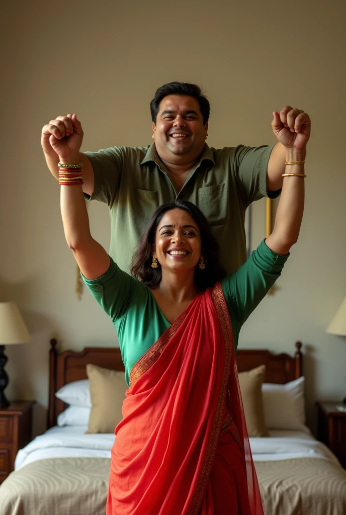 Beautiful and Slim Indian woman Aishwarya Rai in green blouse red saree lifting a large chubby man above her shoulders, man is sitting on woman's shoulders, in a bedroom with high ceiling, natural smile, woman is looking into the camera , full body image 