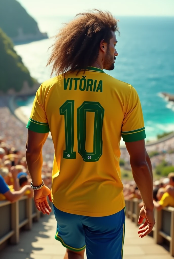 an adult player with big brown hair wearing the Brazilian national team shirt with the name "vitória" number 10 walking around the stadium on the coast