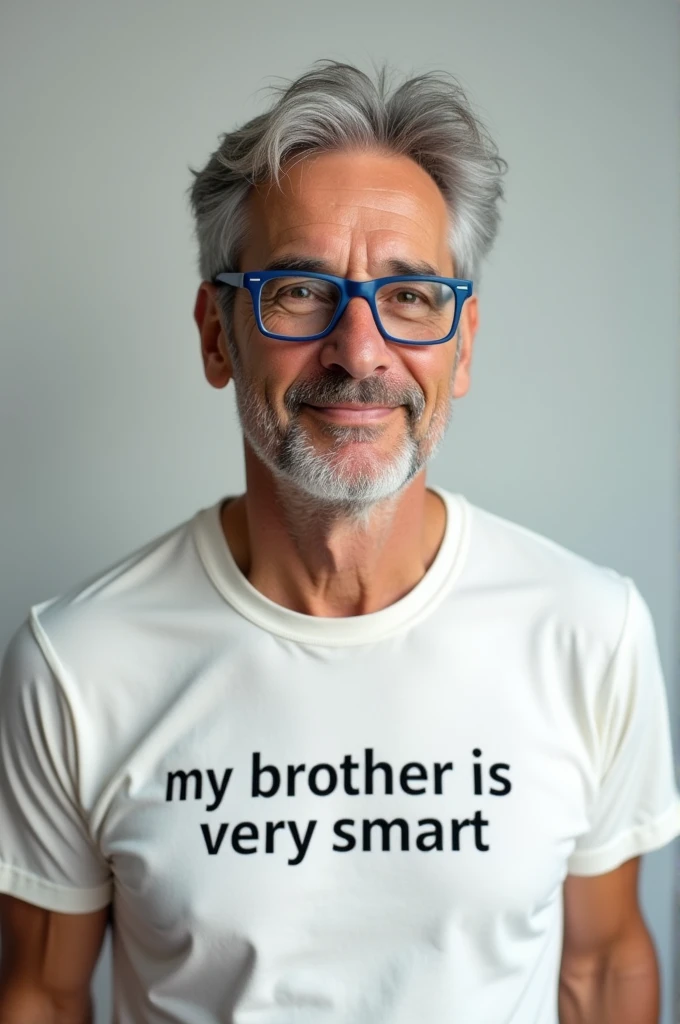 A 50-year-old man with blue glasses wearing a white t-shirt that says my brother is very smart