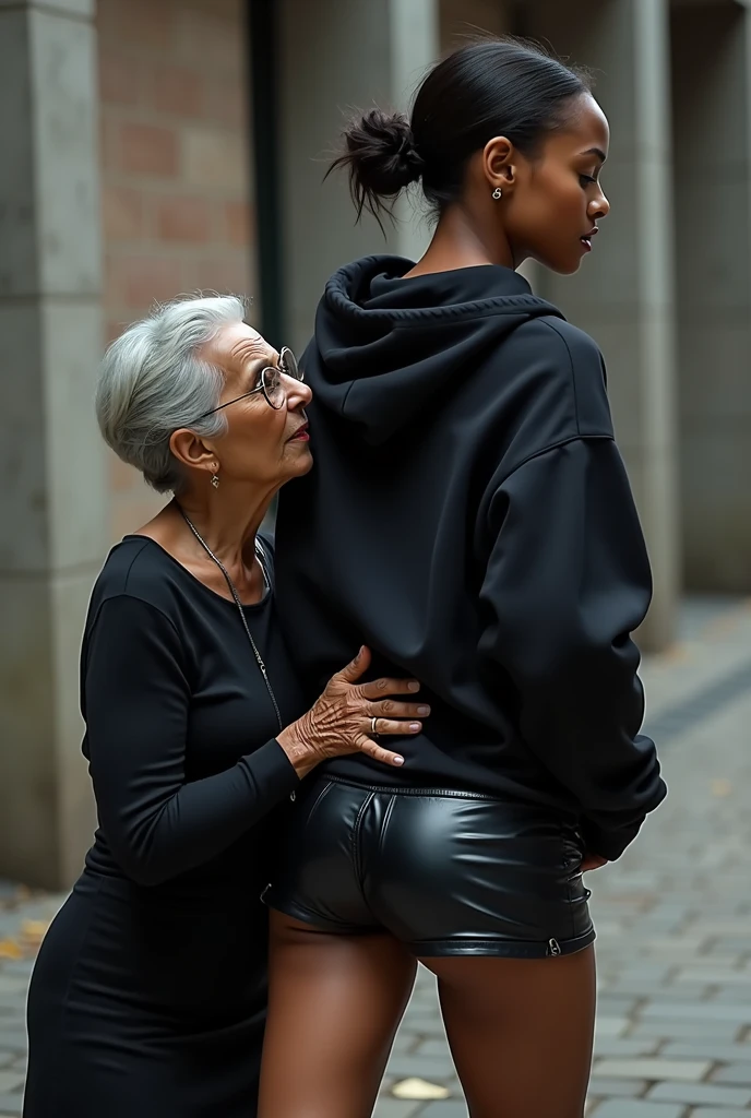 black woman hair in a bun black hoodie black leather short shorts rea;;y in shock as a old grandma in a dress on her knees kissing her ass behind her hand is in her ass holding her ass