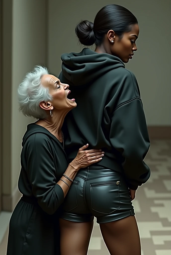 black woman hair in a bun black hoodie black leather short shorts rea;;y in shock as a old grandma in a dress on her knees kissing her ass behind her hand is in her ass holding her ass
