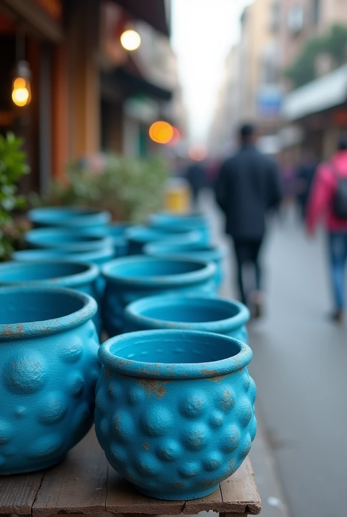 A few thick, lumpy blue paper pots on a street stall, as if the photo had been taken blurry and it was not noticeable