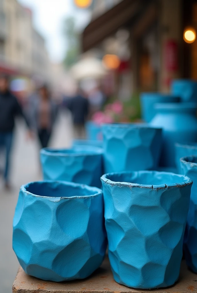 A few thick, lumpy blue paper pots on a street stall, as if the photo had been taken blurry and it was not noticeable