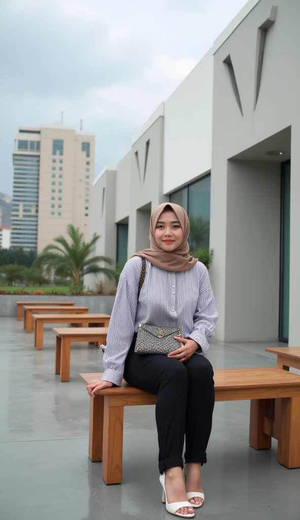 A Potrait Mode young woman wearing a hijab and a striped long-sleeved blouse, sitting on a wooden bench at an outdoor terrace with modern architecture. She has black pants and white high-heeled sandals. She is holding a small patterned bag on her lap and looks relaxed. The terrace is surrounded by a light-colored wall with geometric cutouts, and there are tables and benches around. In the background, there are modern buildings with a minimalistic design and a cloudy sky above. The scene has a calm and serene atmosphere. Detail Realistic With Photografy Style Of Vivid 8K Resolations