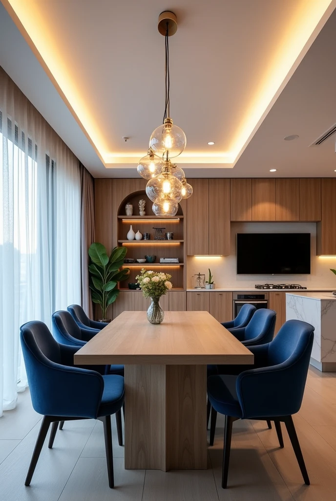 A modern dining room integrated into a kitchen, with elegant design and luxurious touches. The rectangular light wood dining table is surrounded by blue upholstered chairs, creating a sophisticated contrast. Acima da mesa, a glass chandelier with several hanging bulbs illuminates the space elegantly. The kitchen in the background has wood cabinets and stainless steel appliances., with a white marble countertop. The wall next to the table is covered in wood, with a flat-screen TV mounted above a minimalist rack decorated with vases and design items. Indirect lighting built into the ceiling enhances the welcoming and contemporary atmosphere of the space.. Long, translucent curtains cover the window, softening the natural light entering the room