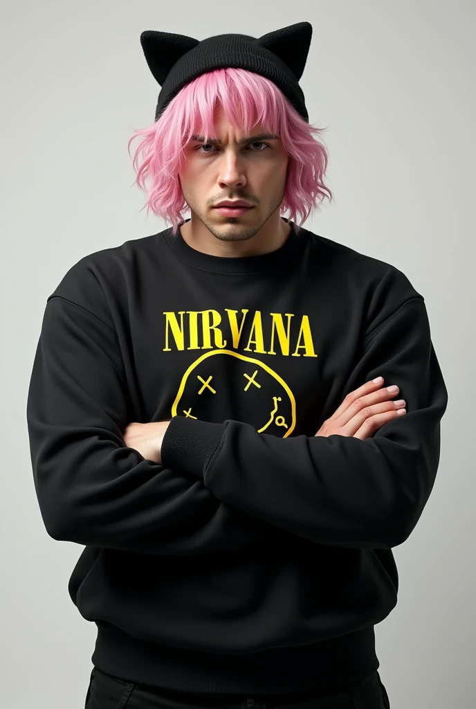 Man with medium short pastel pink hair wearing a black sweater that says Nirvana and black pants with a hat with black cat ears, also with his arms crossed looking straight ahead seriously, you can see he has big breasts 🫦