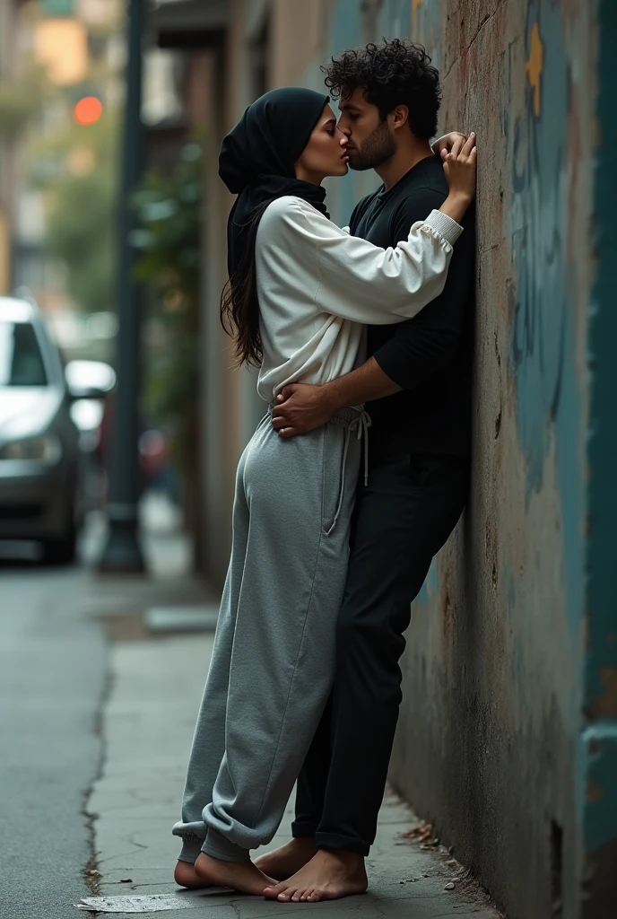 with black headscarf, white long sleeve t shirt, baggy grey sweatpants, barefoot sexy skinny woman. Man kissing woman with her back against the wall on the street.