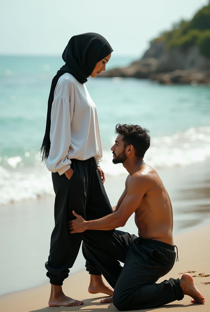 Black headscarf on the beach, white long sleeve t shirt, baggy black sweatpants, barefoot, Sexy skinny woman. Man kneeling in front of woman, Woman touching the front of man&#39;s sweatpants with her foot.