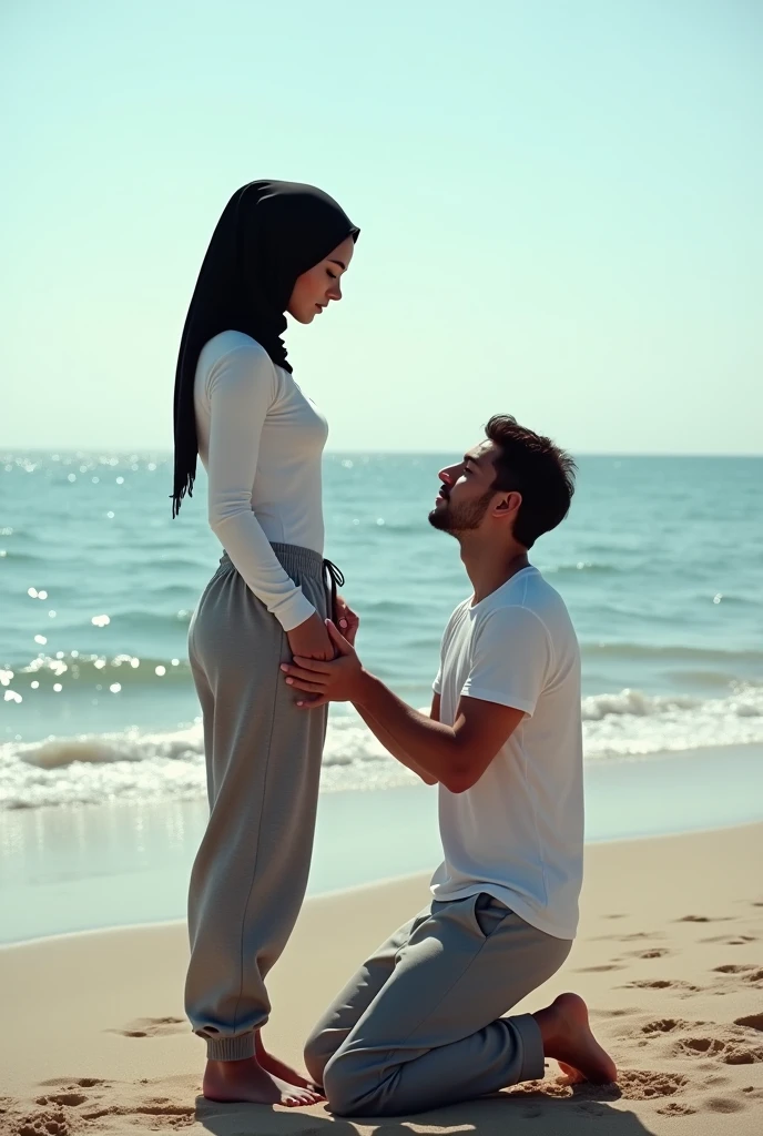 Black headscarf on the beach, white long sleeve t shirt, baggy grey sweatpants, barefoot, Sexy skinny woman. Man kneeling in front of woman, Woman touching the front of man&#39;s sweatpants with her foot.