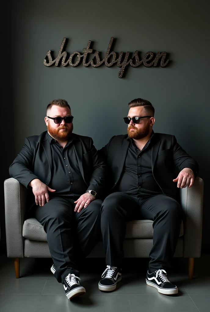 A (2 boy, chubby body habityus , beard, classic taper hair, sunglasses black, writing a black formal shirt and black blazer is sitting on a sofa with one leg up a pair of black and write lace sneakers sitting on a small gray color single sofa dark wall behind light white light shadow coming name written on the wall with capital letters slightly curved 3D text ."SHOTSBYSEN"