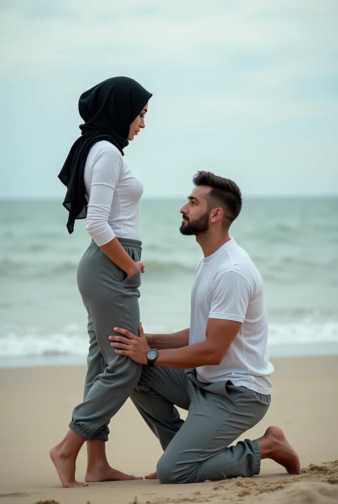 Black headscarf on the beach, white long sleeve t shirt, baggy grey sweatpants, barefoot, Sexy skinny woman. Man kneeling in front of woman, Woman touching the front of man's sweatpants with her foot.