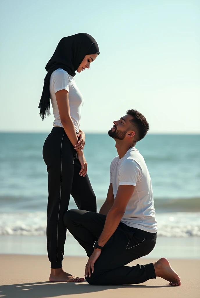 Black headscarf on the beach, black sweatpants, barefoot, white long sleeve t shirt, Sexy skinny woman. Man kneeling in front of woman. Woman puts her foot on the front of man's sweatpants.